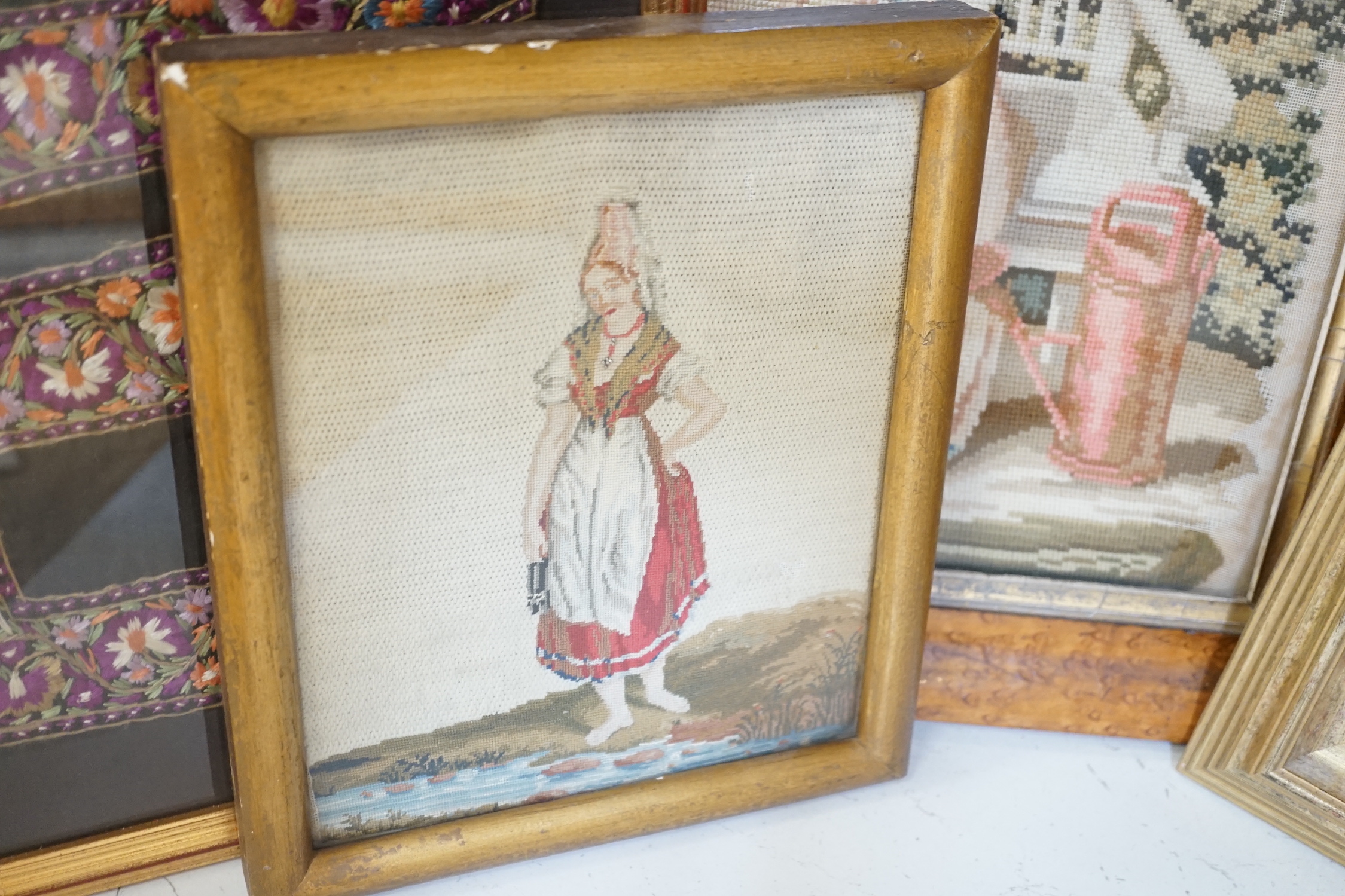 A framed Regency embroidery, two later figurative embroideries and a pair of embroidered slipper fronts, Regency embroidery 37cm wide, 41cm high